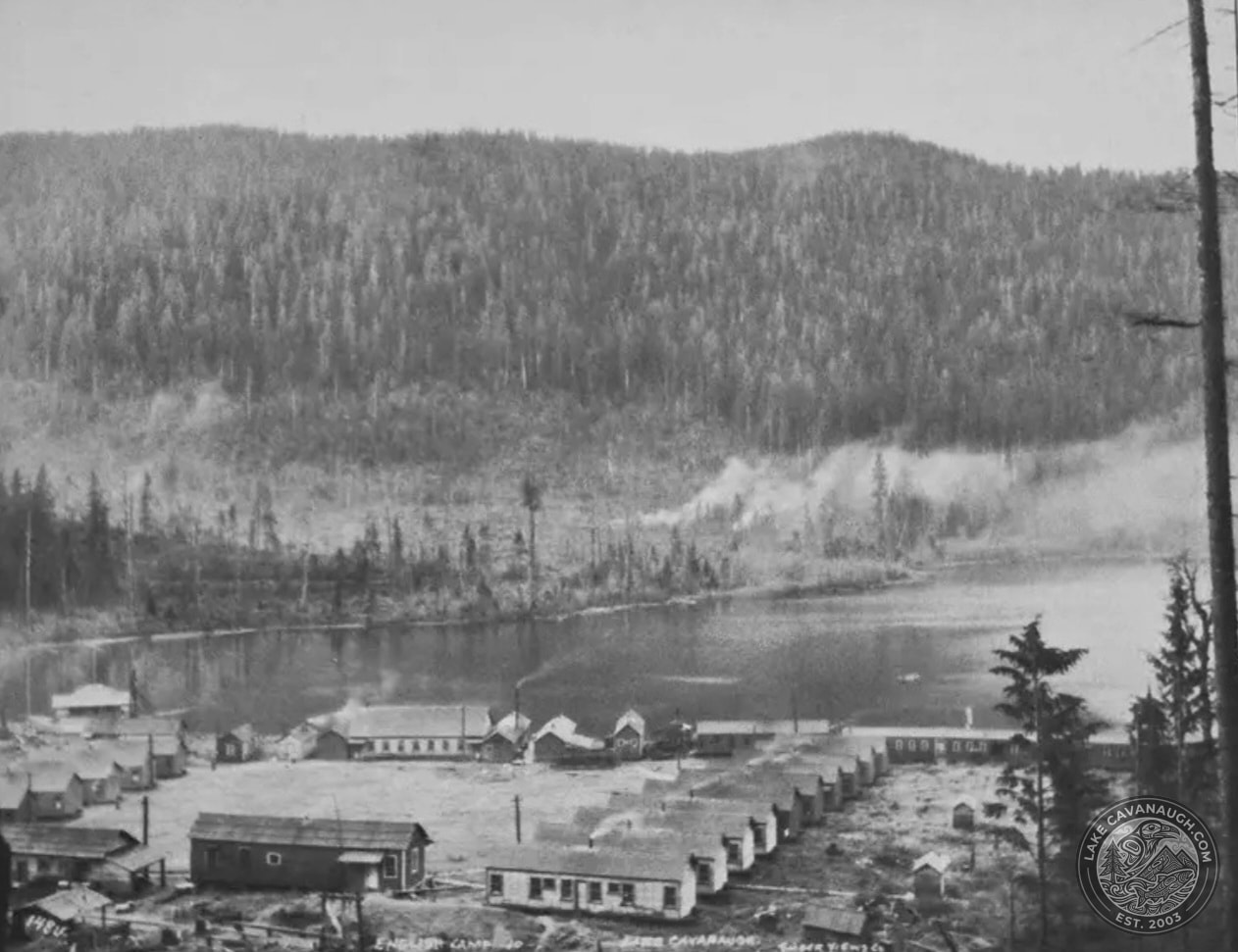 Historic settlement buildings along the north shore of Lake Cavanaugh beneath a forested hillside